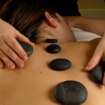 woman receiving a hot stone massage at Elixir Mind Body Massage in Denver