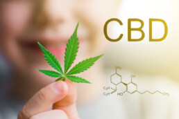 Woman holding a hemp leaf next to CBD molecular formula