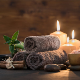 Spa setting with mineral salts, candles, stones and towels