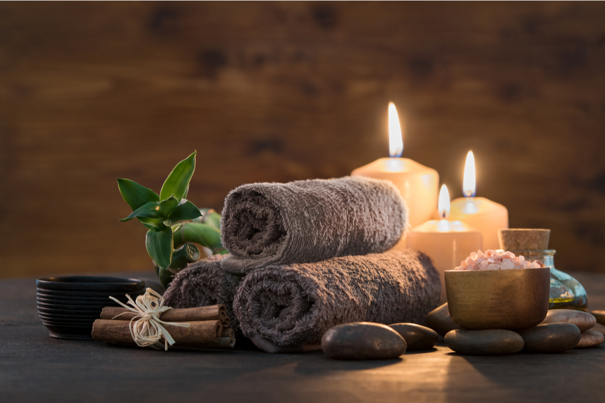 Spa setting with mineral salts, candles, stones and towels