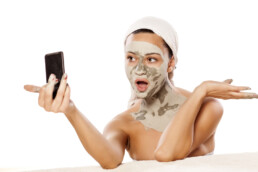 Woman taking a selfie for socal media of her facial mask