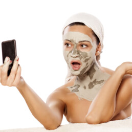 Woman taking a selfie for socal media of her facial mask