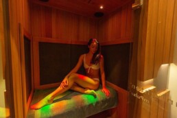 woman sitting in infrared sauna at Elixir Mind Body Massage using chromotherapy