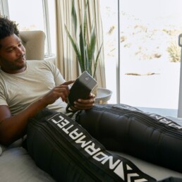 Athlete using Normatec compression therapy post workout