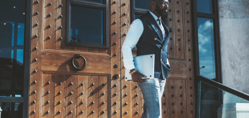 A businessman with a laptop outdoors