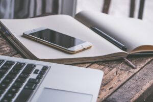 laptop, phone and journal