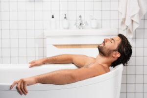 bearded man soaking in a bath tub and relaxing