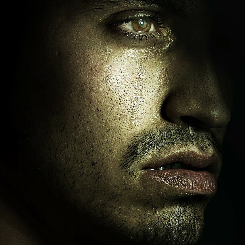 profile of young man with tears on his face staring into distance