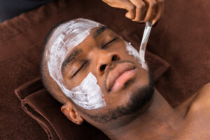Man having a mask applied during a professional facial at Elixir Mind Body Massage