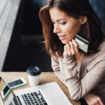 woman at laptop about to reserve her Elixir Mind Body Massage appointment with a credit card